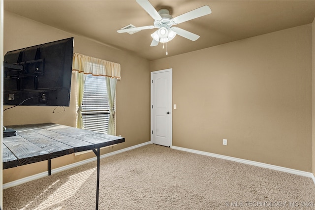 unfurnished office featuring ceiling fan and carpet