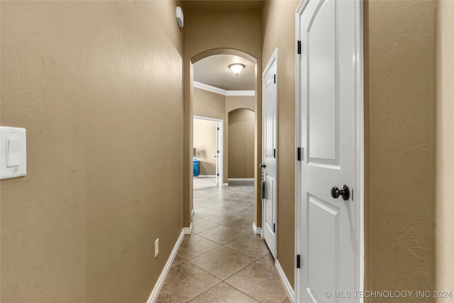 hall featuring ornamental molding and light tile patterned floors