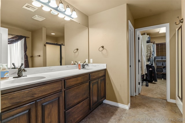 bathroom featuring vanity, a shower with shower door, and tile patterned flooring