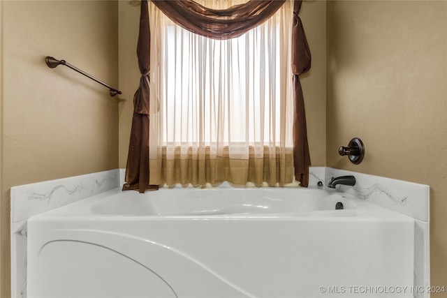 bathroom with a bath and plenty of natural light