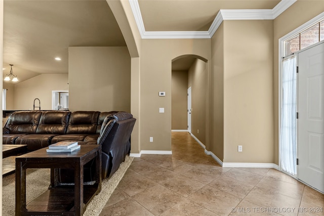 foyer entrance with crown molding, a notable chandelier, and lofted ceiling