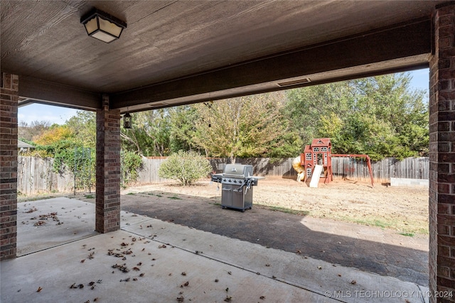 view of patio featuring a grill and a playground