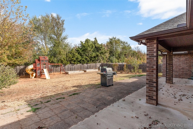 view of patio with a playground and a grill