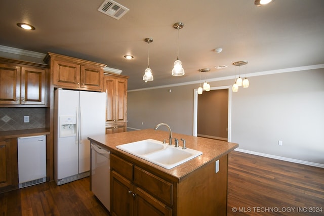 kitchen featuring sink, pendant lighting, a center island with sink, and white appliances