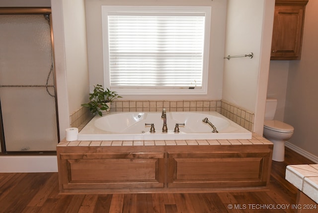 bathroom with a washtub, wood-type flooring, and toilet