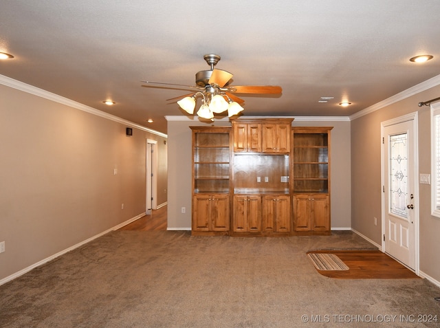 unfurnished living room featuring crown molding, ceiling fan, and dark colored carpet