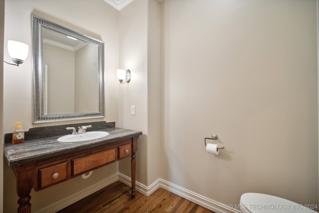 bathroom with toilet, ornamental molding, hardwood / wood-style flooring, and vanity