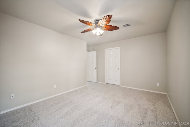 carpeted spare room featuring ceiling fan