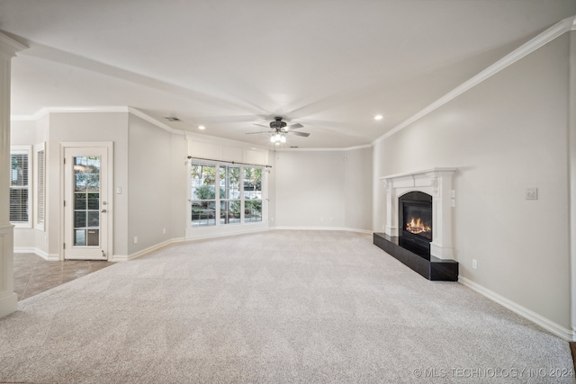 unfurnished living room featuring crown molding, a tiled fireplace, carpet flooring, and ceiling fan