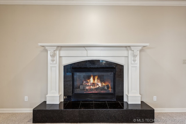 room details with crown molding, a tiled fireplace, and carpet flooring