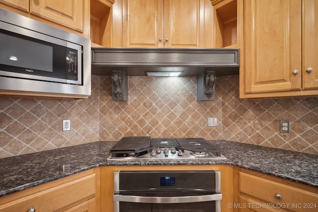 kitchen with appliances with stainless steel finishes, dark stone counters, tasteful backsplash, and extractor fan