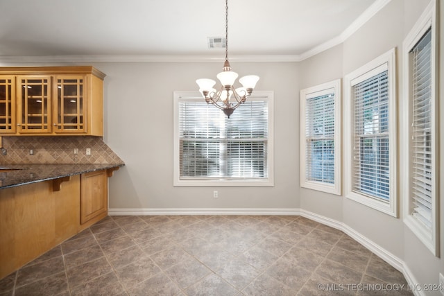 unfurnished dining area with ornamental molding, sink, a notable chandelier, and tile patterned flooring