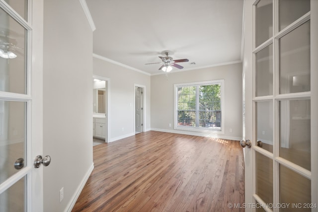 spare room featuring french doors, crown molding, wood-type flooring, and ceiling fan