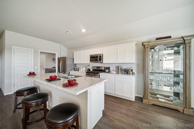 kitchen featuring dark hardwood / wood-style floors, a kitchen breakfast bar, stainless steel appliances, a center island with sink, and white cabinetry