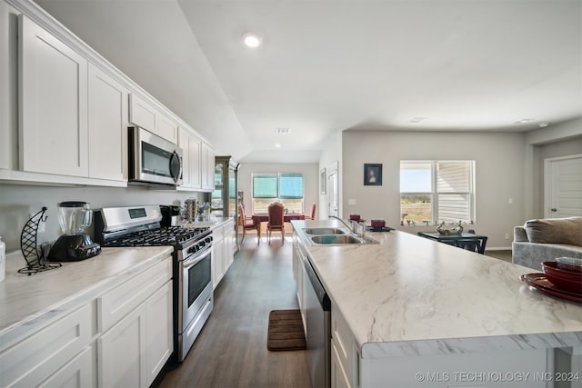 kitchen featuring lofted ceiling, white cabinets, dark hardwood / wood-style flooring, sink, and stainless steel appliances