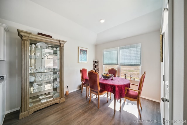 dining area with vaulted ceiling and dark hardwood / wood-style floors