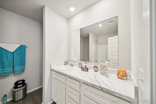 bathroom with vanity, hardwood / wood-style floors, and a shower