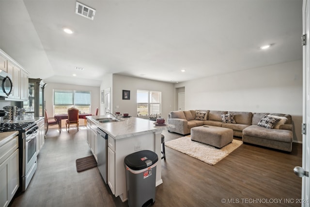 kitchen featuring a center island with sink, white cabinets, stainless steel appliances, and plenty of natural light