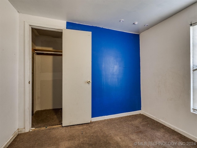 unfurnished bedroom featuring carpet flooring and a closet