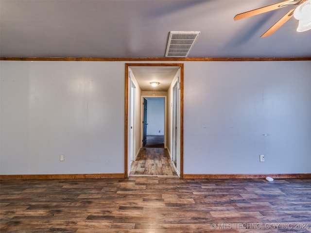 empty room featuring ceiling fan, dark hardwood / wood-style flooring, and crown molding