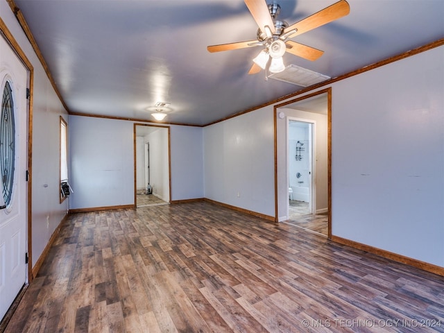 spare room featuring dark hardwood / wood-style floors, ceiling fan, and crown molding