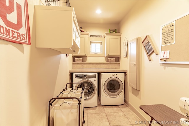 laundry room featuring light tile patterned floors, separate washer and dryer, and cabinets