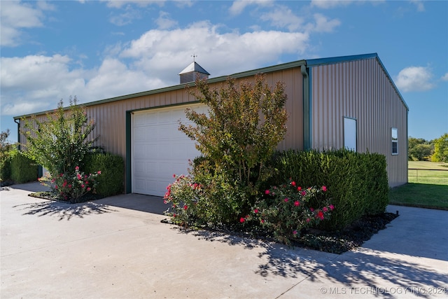 view of property exterior with an outdoor structure and a garage