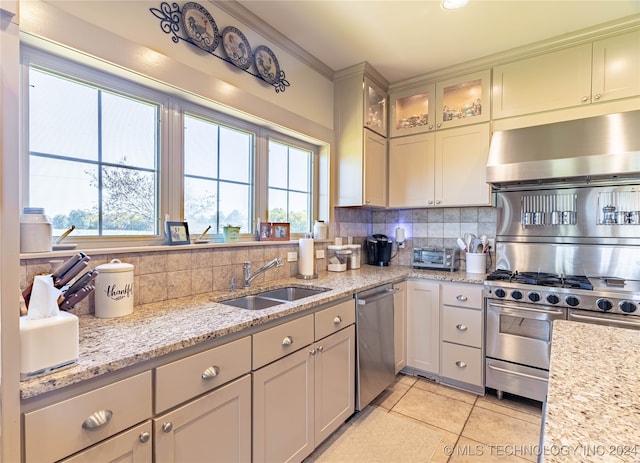 kitchen with appliances with stainless steel finishes, sink, plenty of natural light, and decorative backsplash