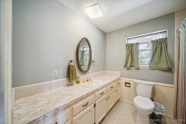 bathroom with a shower with shower curtain, vanity, and toilet