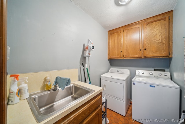 laundry area with cabinets, sink, separate washer and dryer, and a textured ceiling