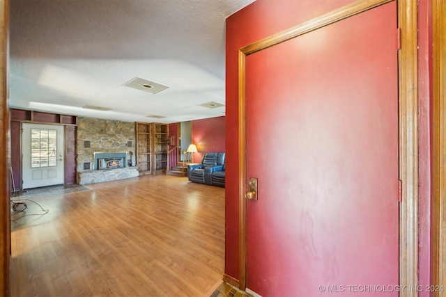 interior space featuring a textured ceiling, hardwood / wood-style flooring, and a fireplace