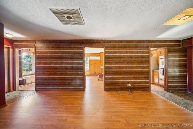 unfurnished living room featuring hardwood / wood-style floors and a textured ceiling