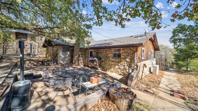 back of property with central AC unit and a patio area