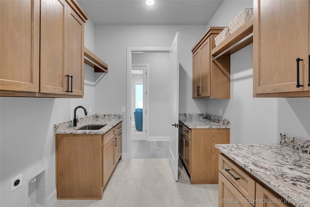 kitchen with light stone counters and sink