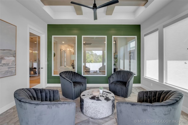 sunroom with a tray ceiling and ceiling fan