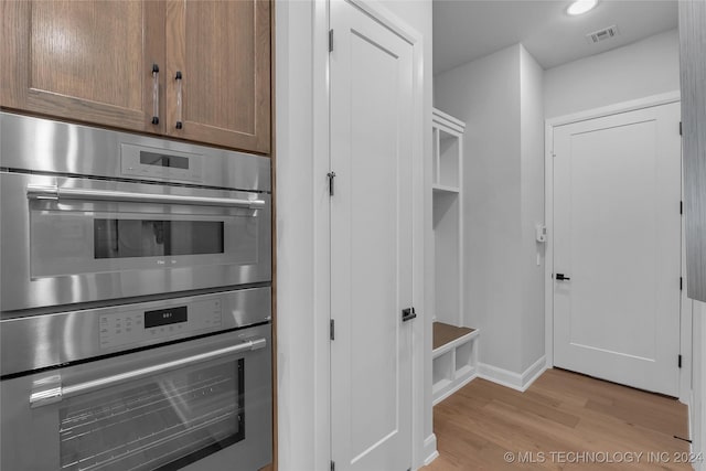 kitchen featuring double oven and light hardwood / wood-style flooring