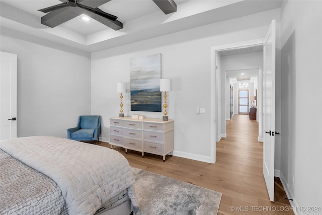 bedroom featuring ceiling fan, beam ceiling, and light wood-type flooring