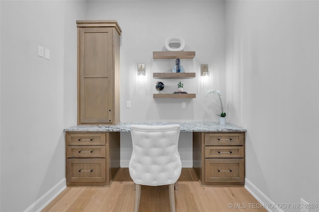 office area with built in desk and light hardwood / wood-style flooring