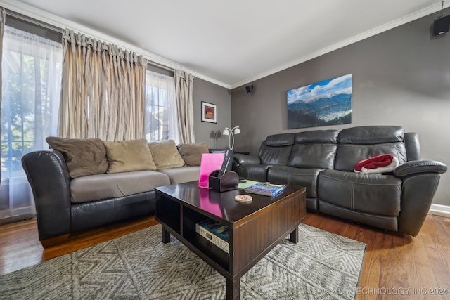 living room featuring ornamental molding, wood-type flooring, and plenty of natural light