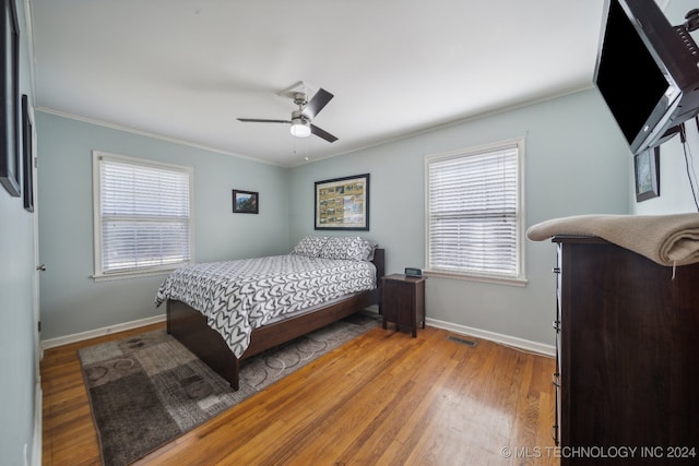 bedroom featuring crown molding, hardwood / wood-style flooring, and ceiling fan