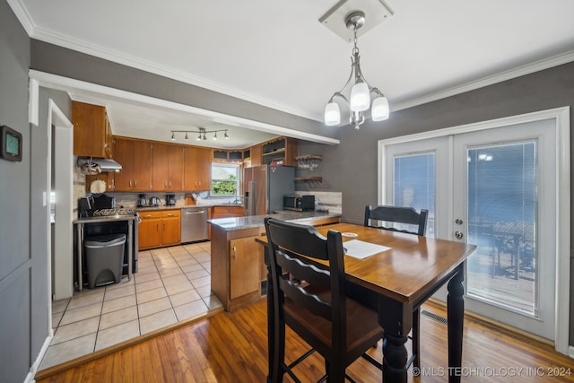 dining space featuring light hardwood / wood-style flooring, french doors, a chandelier, and crown molding