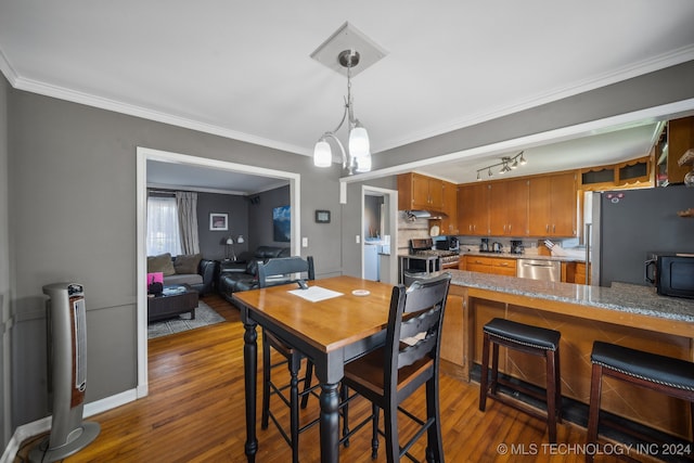 dining room featuring crown molding, a notable chandelier, and dark hardwood / wood-style floors