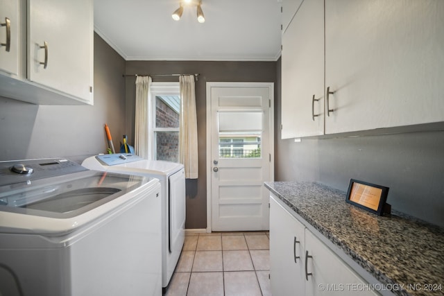 laundry area featuring crown molding, cabinets, washer and clothes dryer, and light tile patterned floors