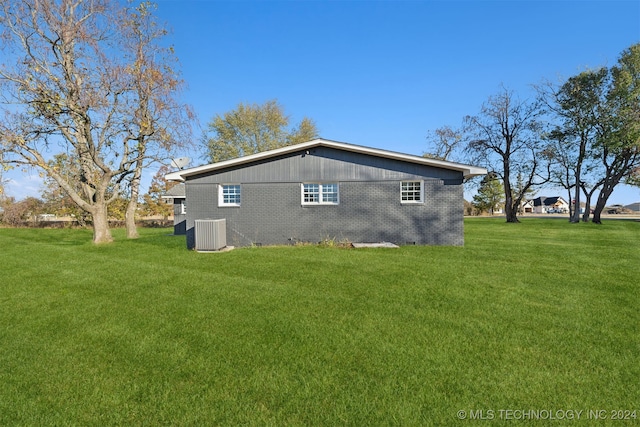 rear view of house with a yard and central AC unit