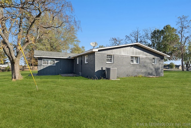 rear view of property with a yard and central AC