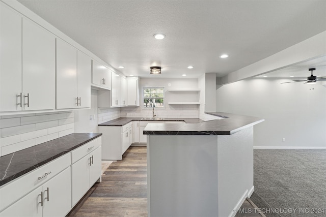 kitchen with tasteful backsplash, sink, white cabinets, and ceiling fan