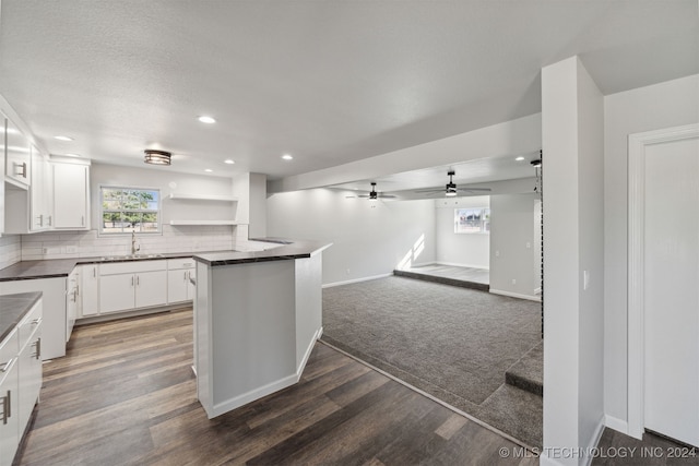 kitchen featuring sink, white cabinets, dark hardwood / wood-style flooring, decorative backsplash, and kitchen peninsula