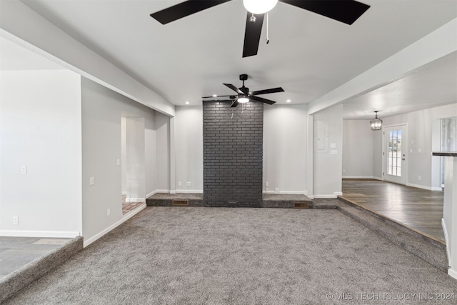 unfurnished living room featuring ceiling fan and dark colored carpet