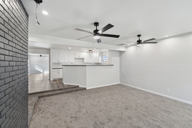 unfurnished living room featuring ceiling fan and carpet