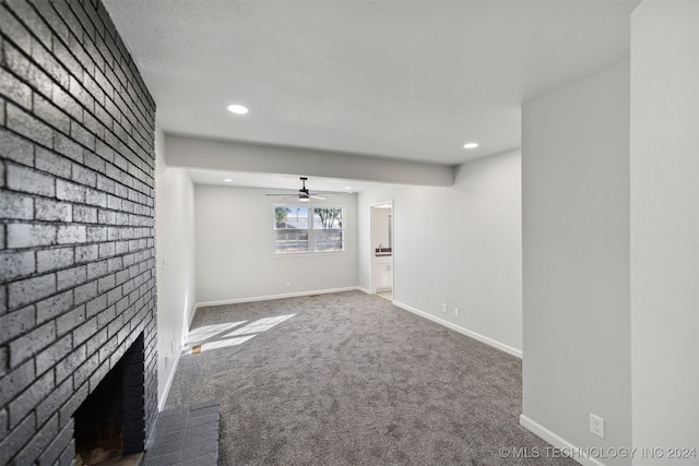 unfurnished living room with brick wall, a fireplace, ceiling fan, and carpet